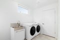 A white laundry room with a white washer and dryer.