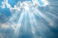 Beautiful sun rays shining through the fluffy white clouds in the clear blue sky Royalty Free Stock Photo