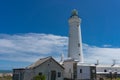 Bright white lighthouse against blue sky on sunny day Royalty Free Stock Photo