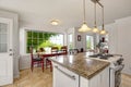 Bright white modern kitchen interior with island and dining area Royalty Free Stock Photo