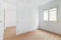 Bright white spacious unfurnished apartment with an window and wooden textured laminate. Concept of modern building or