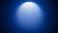 Bright white spotlight beam illuminating a deep blue gradient background with subtle light rays Keywords: spotlight Royalty Free Stock Photo