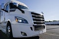 Bright white stylish big rig semi truck standing on truck stop at sunshine time Royalty Free Stock Photo