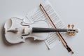 White Violin with Bow and Sheet Music on Studio Surface Royalty Free Stock Photo