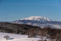 Bright winter color landscape scene of a snow field and a view towards a mountain Royalty Free Stock Photo