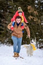 Bright winter day dad with daughter in the woods with their dog, fun walk in the snowy forest Royalty Free Stock Photo