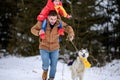 Bright winter day dad with daughter in the woods with their dog, fun walk in the snowy forest Royalty Free Stock Photo