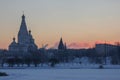 Bright winter morning. bright scarlet sun rises on the horizon because of the houses and the Church. frosty clear weather on the