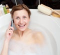 Bright woman talking on phone in a bubble bath Royalty Free Stock Photo