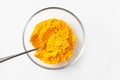 Close-up of turmeric powder in a bowl with a spoon on a white background Royalty Free Stock Photo