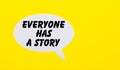 On a bright yellow background, white paper with the words Everyone has a story Royalty Free Stock Photo