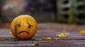 Yellow Ball With Sad Face Drawn on It