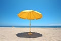 bright yellow beach umbrella on the sand with a blue sky in the background, Generative AI