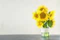 Bright yellow big sunflowers in glass vase on dark table on light texture background. Mockup banner with sunflower bouquet with c Royalty Free Stock Photo