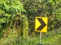 ?A bright yellow chevron sign indicates a sharp turn on road Royalty Free Stock Photo