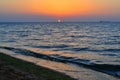 bright yellow circle of sun pink orange dawn at sea coast, shore with waves, sunset Royalty Free Stock Photo