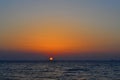 Bright yellow circle of sun pink orange red dawn, sunset at sea, ocean, sky gradient, evening
