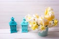 Bright yellow daffodils and tulips flowers in pot and blue deco