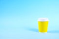 Colorful simplistic minimal composition with heat proof paper coffee cup. Take out tea mug with plastic cap. Coffee shop concept. Royalty Free Stock Photo