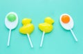 Bright yellow duck shaped candies and duck egg shaped candies on light green background. Royalty Free Stock Photo