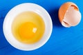 Bright yellow egg yolk in white bowl on old wooden table Royalty Free Stock Photo