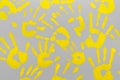 Bright yellow family handprints on a gray background. Positive and hope