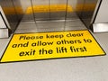 Please keep clear and allow others to exit the lift first sign in Manchester UK Royalty Free Stock Photo