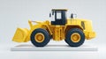 A bright yellow front-end loader sits on a white platform, ready for work. Royalty Free Stock Photo