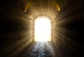 A bright yellow glowing light breaking through at the end of a dark tunnel Royalty Free Stock Photo