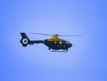 a large yellow helicopter flying through a blue sky of some sort