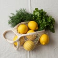 Bright Yellow Lemons and Fresh Herbs in Mesh Bag Royalty Free Stock Photo
