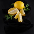 Bright yellow lemons, slices, rustic food photography on dark slate plate kitchen table Royalty Free Stock Photo