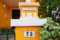 A bright yellow little house is a mailbox in a lisbon in the leaves of a tree. Royalty Free Stock Photo