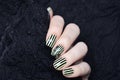 Bright yellow manicure with black stripes and sunflowers pattern on black background Royalty Free Stock Photo