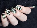 Bright yellow manicure with black stripes and sunflowers pattern on black background Royalty Free Stock Photo