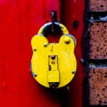 Bright Yellow Padlock Against A Red Painted Door Royalty Free Stock Photo