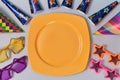 Bright yellow plate and decoration set for holiday. Colourful glasses and head caps. Party concept. Isolated on light