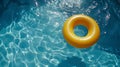 Bright yellow pool float ring in refreshing blue water of a swimming pool, perfect for relaxation Royalty Free Stock Photo