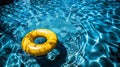 Bright yellow pool float and ring serenely floating in refreshing blue swimming pool Royalty Free Stock Photo