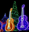 Yellow and Purple Guitars and Holiday Tree and Ornaments lit up Royalty Free Stock Photo