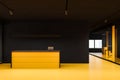 Bright yellow reception in black office hall