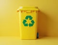 Bright yellow recycling bin with green recycling symbol on yellow background. Container made of plastic, designed for waste Royalty Free Stock Photo