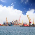 Bright yellow, red and orange cranes and freighters stand in the