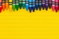 Bright yellow ruled line notebook paper with crayons background