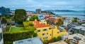 Bright yellow San Francisco apartment building with green roof and distant Aquatic Cove aerial, CA Royalty Free Stock Photo