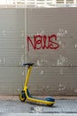 Bright yellow scooter parked in front of a wall with the word Royalty Free Stock Photo