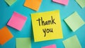 Bright yellow sticky note displays Thank in collection of colorful post-it notes on vibrant blue backdrop. Image represents Royalty Free Stock Photo