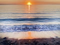 A gorgeous sunset with waves and beautiful orange reflections in the water in the sand in Manasota Beach in Englewood, Florida. Royalty Free Stock Photo