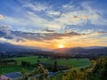 bright yellow sunset in clouds over hills. Blue sky and green fields. Slovenia. Evening. Maribor. Europe Royalty Free Stock Photo