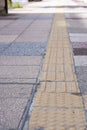 Bright yellow tactile footpath for people who have visually impaired on the walkway.